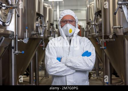 Brewery technologist standing between the fermentation tanks Stock Photo