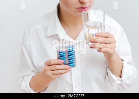 Women's hand with pills, blister with blue capsuls. Medical insurance, medical treatment concept. Disease, sick treatment, cold season concept. Close- Stock Photo