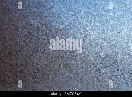Natural background, texture of frosty patterns. Beautiful ice crystals on glass during frosts Stock Photo