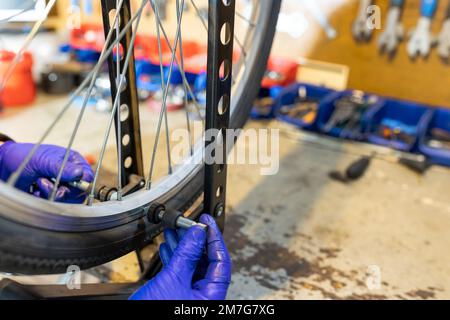 Cycling technician repairing and maintaining bike and gear shifter in workshop Stock Photo