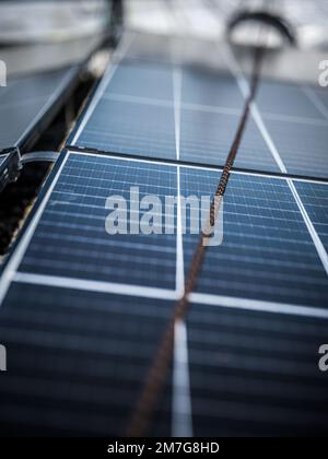 rope for workers installing solar panels on the roof of a company Stock Photo
