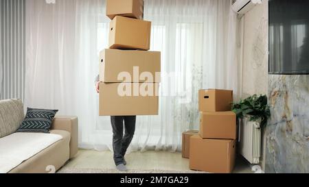 Man carries boxes stack and falls on floor in new apartment Stock Photo