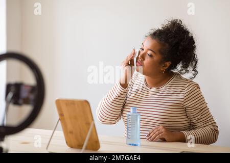 Young lady plus size using face toner and recording video Stock Photo