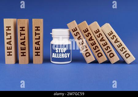 Medical concept. On a blue background, wooden plates with the inscription health and disease, in the middle a white jar with the inscription - STOP AL Stock Photo