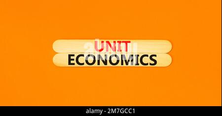 Unit economics symbol. Concept words Unit economics on wooden stick. Beautiful orange table orange background. Business and unit economics concept. Co Stock Photo