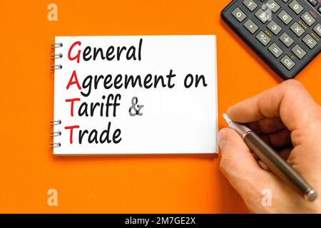 GATT symbol. Concept words GATT general agreement on tariff and trade on white note on beautiful orange background. Business GATT general agreement on Stock Photo