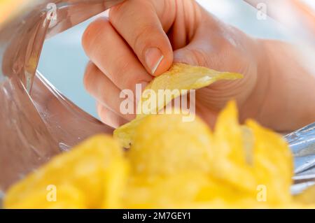 Hand holding potato chips inside snack foil bag Stock Photo