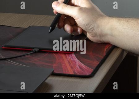 Graphic designer using a pen on a digital tablet. Stock Photo