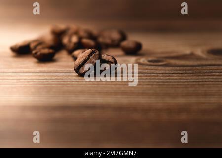 close up of coffee beans on brown wooden table Stock Photo
