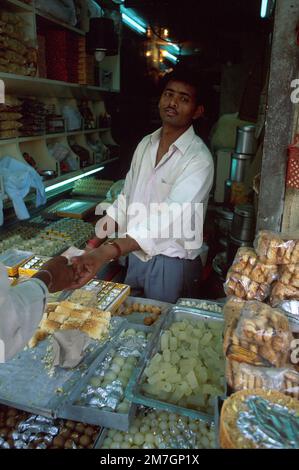 Sweet-seller taking money, Old Delhi, New Delhi, India Stock Photo