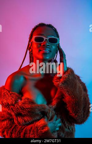 Attractive black ethnic woman with braids with red and blue led lights, trap dancer wearing sunglasses Stock Photo