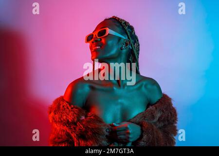 Attractive black ethnic woman with braids with red and blue led lights, trap dancer wearing sunglasses Stock Photo