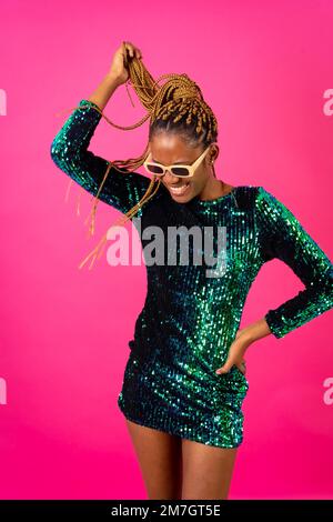African young woman with party braids on a pink background, smiling in a pose Stock Photo