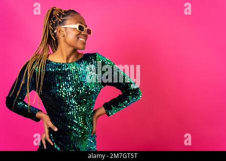 African young woman with party braids on a pink background, studio portrait dancing Stock Photo