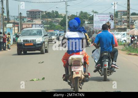 Motorcycle cabs or moto taxi seen from behind, carrying passengers in the streets of Yaounde in Cameroon Stock Photo