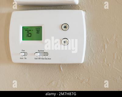 Programmable digital thermostat set to energy saving 78 degrees. Wall mounted temperature controller for home air conditioning and heating system. Stock Photo