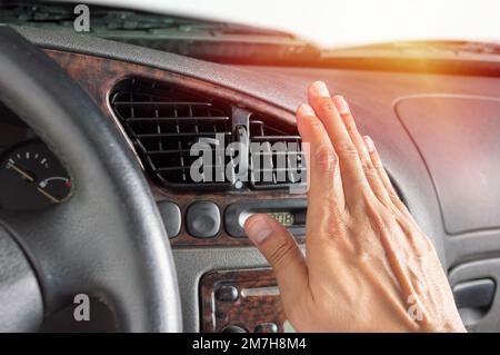 Closeup of hand driver man checking adjusting air from conditioning the cooling system with flow of cold air in car. Stock Photo