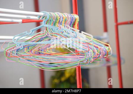 cloth hanger multi colored - colorful old plastic aluminum clothes hanger on the clothesline Stock Photo