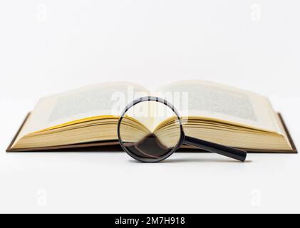 Magnifying glass and book isolated on white Stock Photo