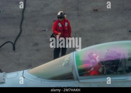 USS Nimitz, United States. 02 January, 2023. U.S. Navy flight deck crews perform check on a F/A-18E Super Hornet fighter aircraft on the flight deck of the Nimitz-class aircraft carrier USS Nimitz underway conducting routine operations, January 2, 2023 in the Philippine Sea.  Credit: MC1 Nathan Laird/U.S Navy Photo/Alamy Live News Stock Photo