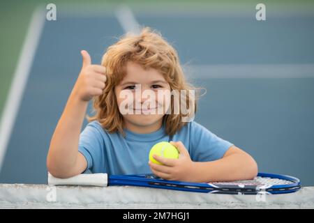 Tennis. Child playing tennis on indoor court. Little child with tennis racket and ball in sport club. Active exercise for kids. Summer activities for Stock Photo