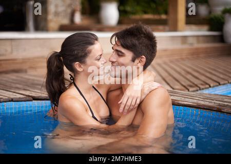 Lost in each other. a young couple relaxing in the jacuzzi. Stock Photo