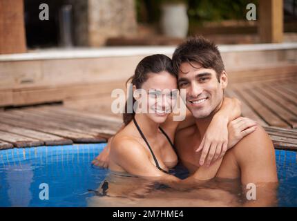 Theyre enjoying their holiday together. Portrait of an attractive couple embracing in a pool. Stock Photo