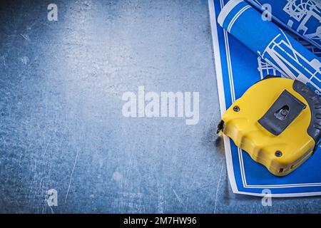 Assortment of blue construction plans measuring tape on metallic background. Stock Photo