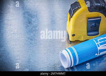 Blue engineering drawings tape measure on metallic background construction concept. Stock Photo