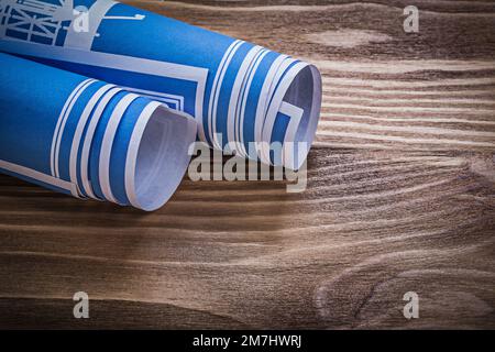 Blue rolled engineering drawings on wooden board construction concept. Stock Photo