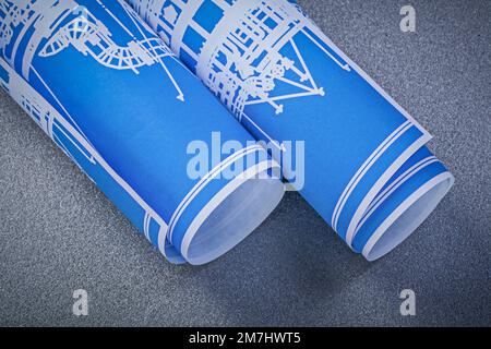 Blue rolled engineering drawings on grey background construction concept. Stock Photo
