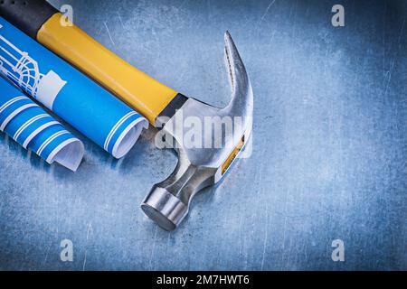 Blue rolled engineering drawings claw hammer on metallic background ...