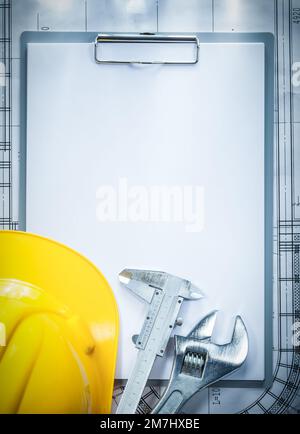 Clipboard building helmet adjustable spanner vernier caliper on blueprint construction concept. Stock Photo