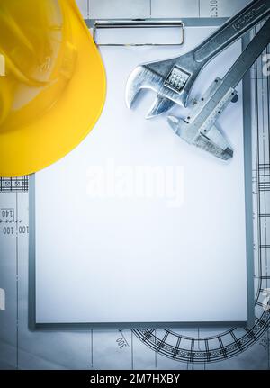 Clip board hard hat adjustable spanner slide caliper on blueprint. Stock Photo