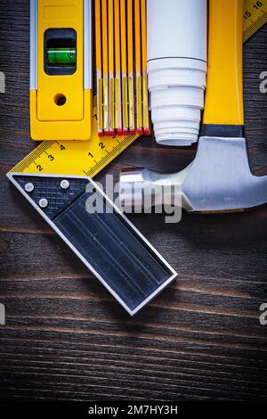Construction level square ruler blueprint roll wooden meter and claw hammer on vintage wood board architecture and building concept. Stock Photo