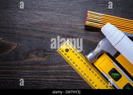 Construction level white blueprints instruments of measurement and claw hammer on vintage wood surface maintenance concept. Stock Photo