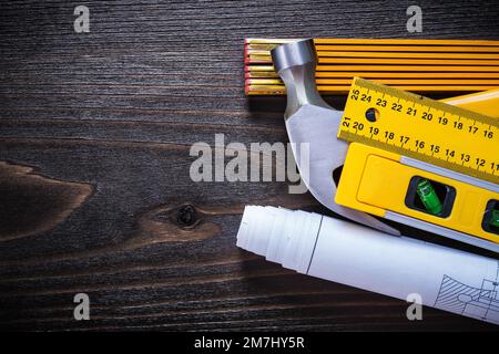 Construction level white blueprints instruments of measurement and hammer on vintage wood board maintenance concept. Stock Photo