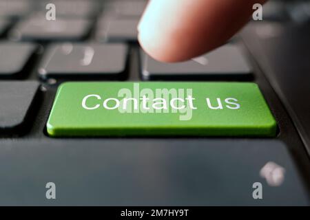 Big green contact us keyboard button. contact inscriptions on the keyboard button, green button. Stock Photo