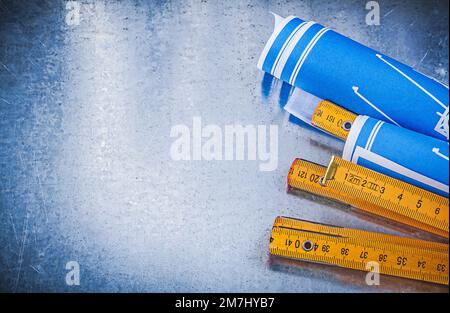 Copyspace of blue construction drawings wooden meter on metallic background. Stock Photo