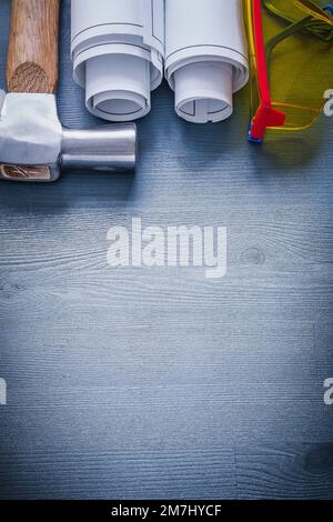 Close up image of rolled blueprints construction level claw hammer on ...