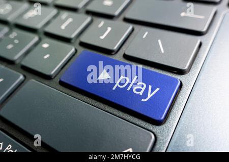 A colored button with the inscription play on a black keyboard. Stock Photo