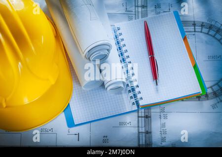 Protective hard hat checked notebook pen blueprints on construction plan. Stock Photo