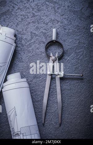 Rolled blueprints divider on black background maintenance concept. Stock Photo