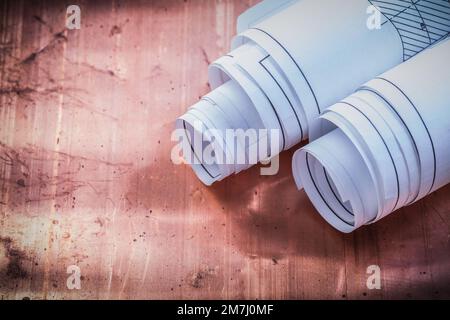 Rolled blueprints on brazen background construction concept. Stock Photo