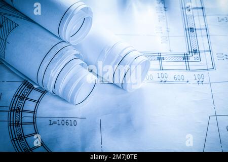 Rolled construction plans on blueprint. Stock Photo