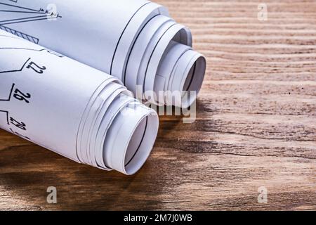 Rolled engineering drawings on wooden board construction concept. Stock Photo