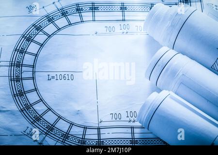 Rolled up construction plans on blueprint top view. Stock Photo