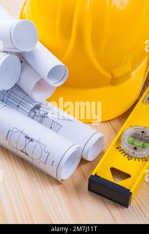Rolls of blueprints helmet and yellow construction level Stock Photo ...