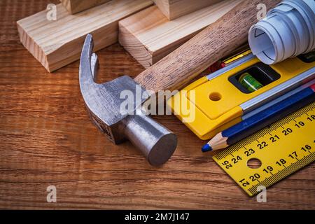 Ruler pencil blueprints wooden bricks construction level and claw hammer on vintage wood board maintenance concept. Stock Photo