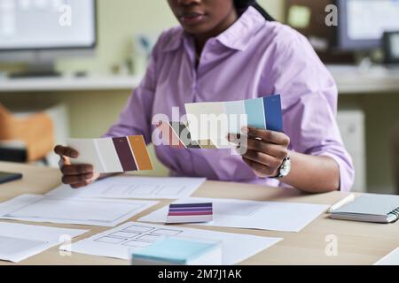 Close up of black young woman as creative designer holding color swatches in office, copy space Stock Photo